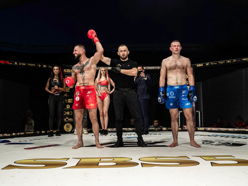 Marcin Kujawa z podniesioną ręką po wygranej walce w ringu