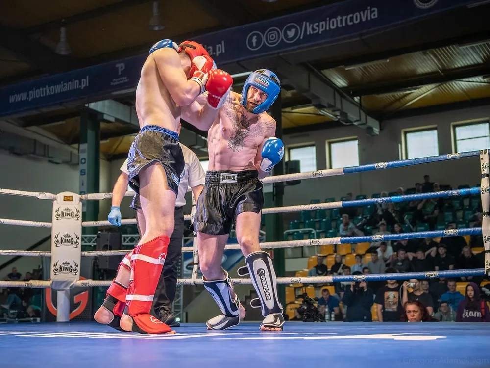 Walka amatorska w kaskach i nagolennikach podczas turnieju kickboxingu
