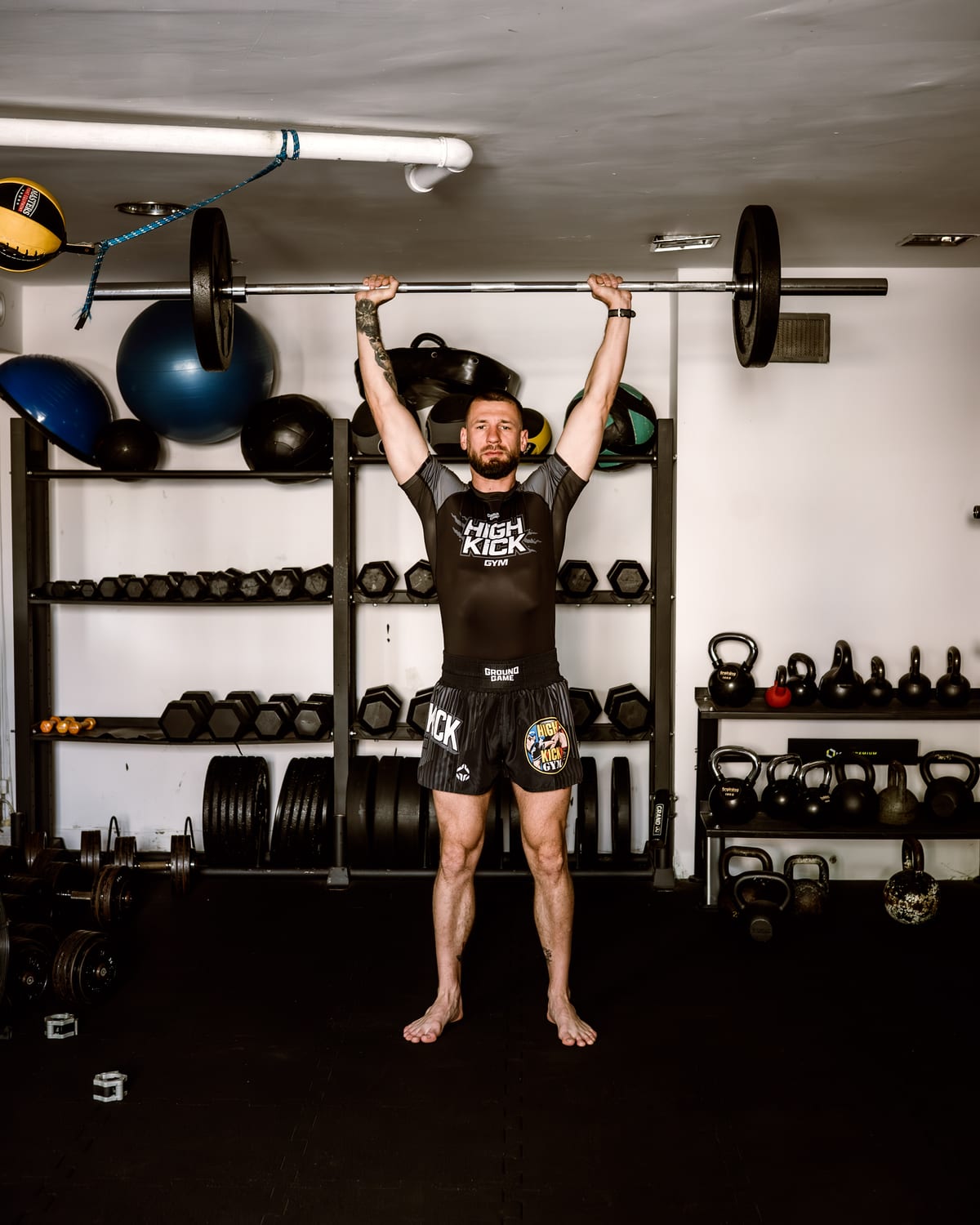 Wyciskanie sztangi nad głowę (OHP) w sali treningowej High Kick Gym