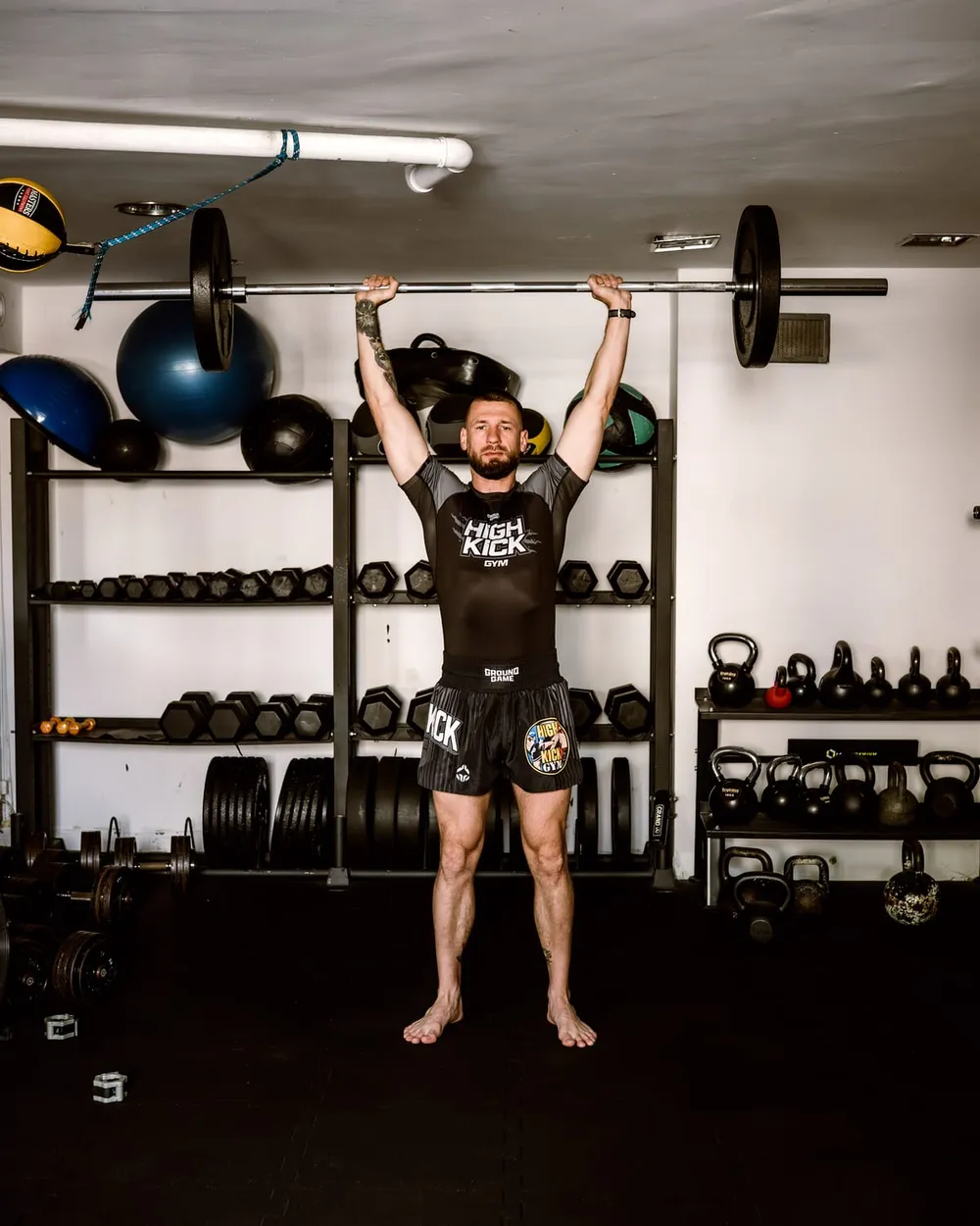Wyciskanie sztangi nad głowę (OHP) w sali treningowej High Kick Gym