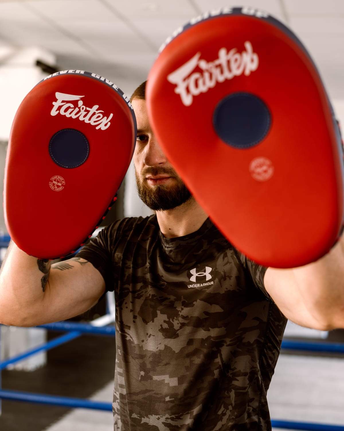 Trener trzyma dwie tarcze Fairtex, gotowy do sesji sparingowej